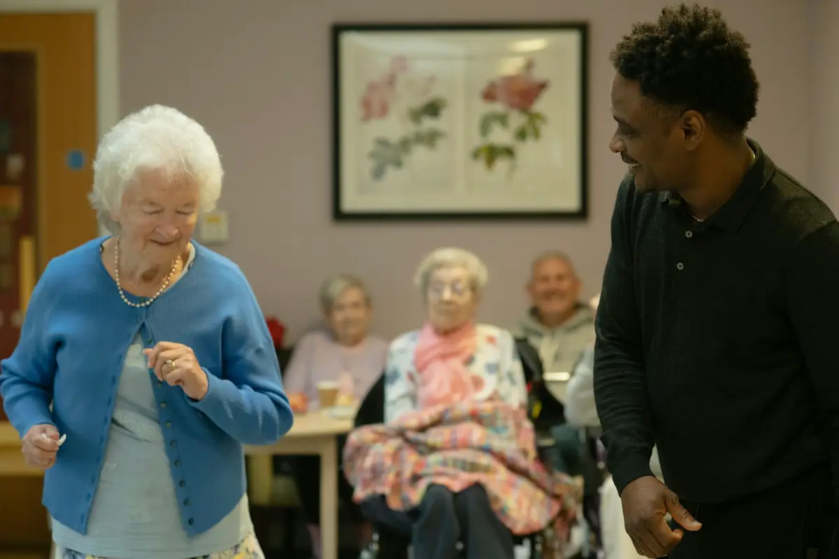 A resident dancing with a carer